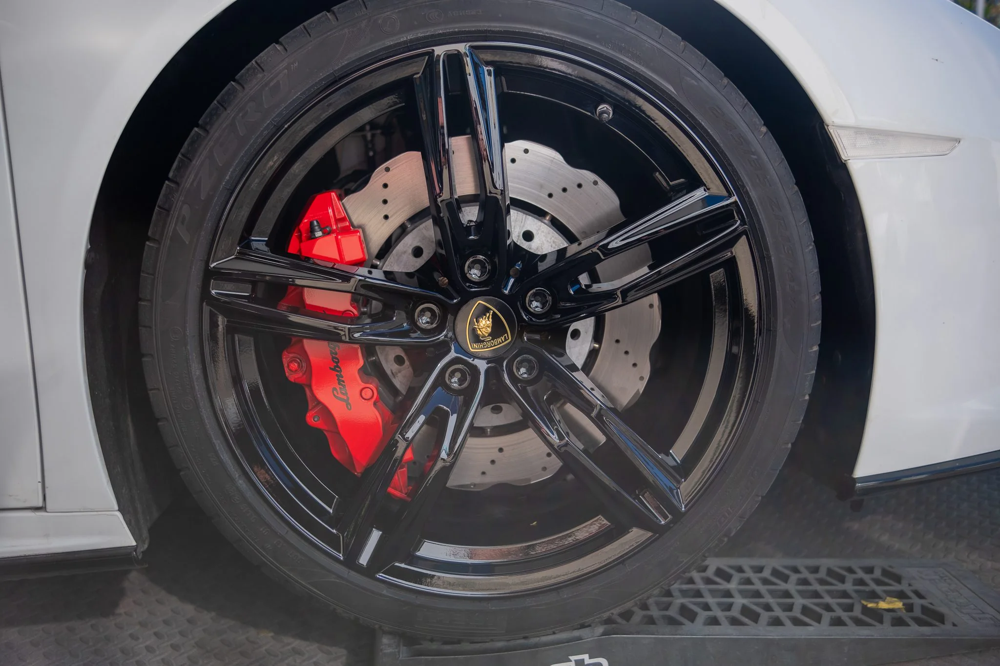 A refinished black alloy wheel on a Lamborghini